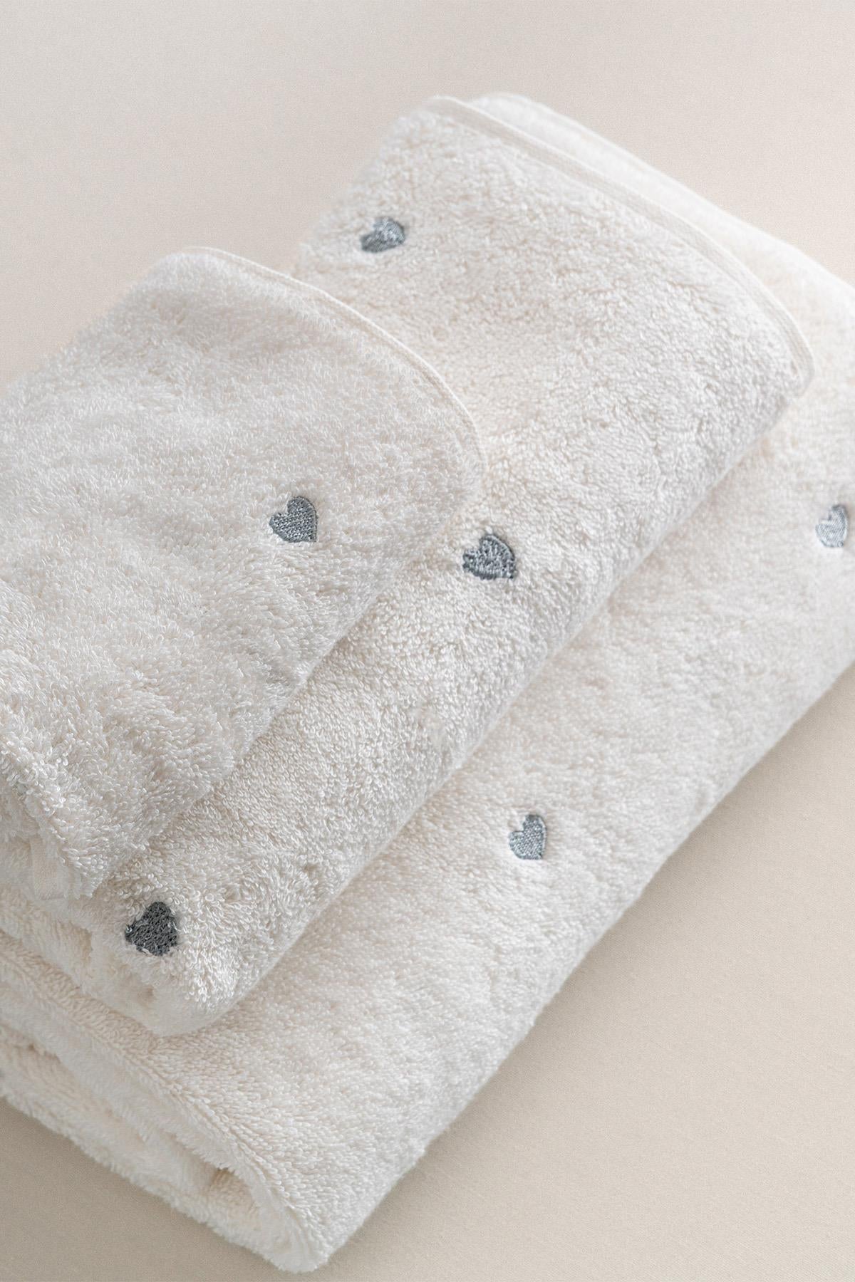 White towel set with silver heart detail, soft texture, comfortable bathroom accessory