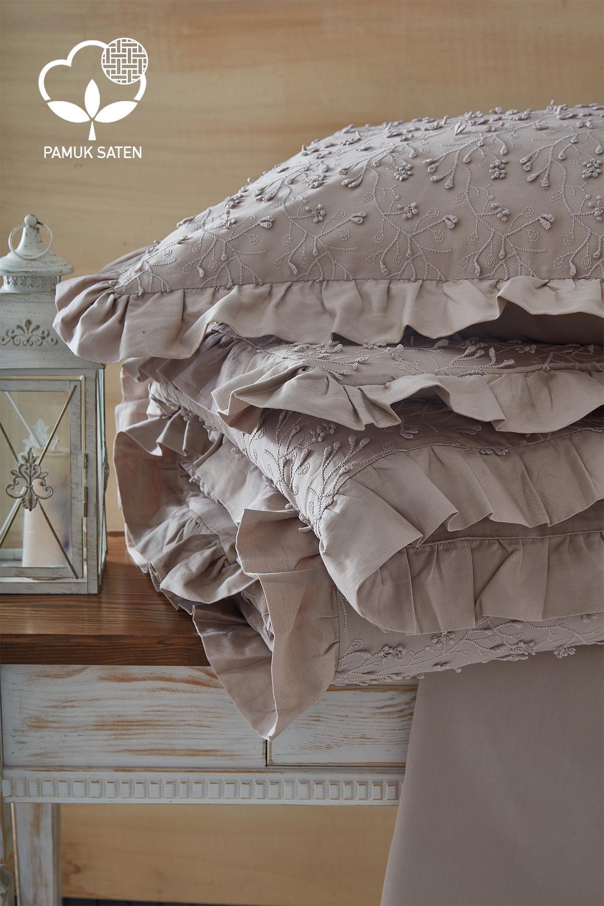 Embroidered cotton sateen double duvet cover set with lace details, laid out on a cream-colored table.