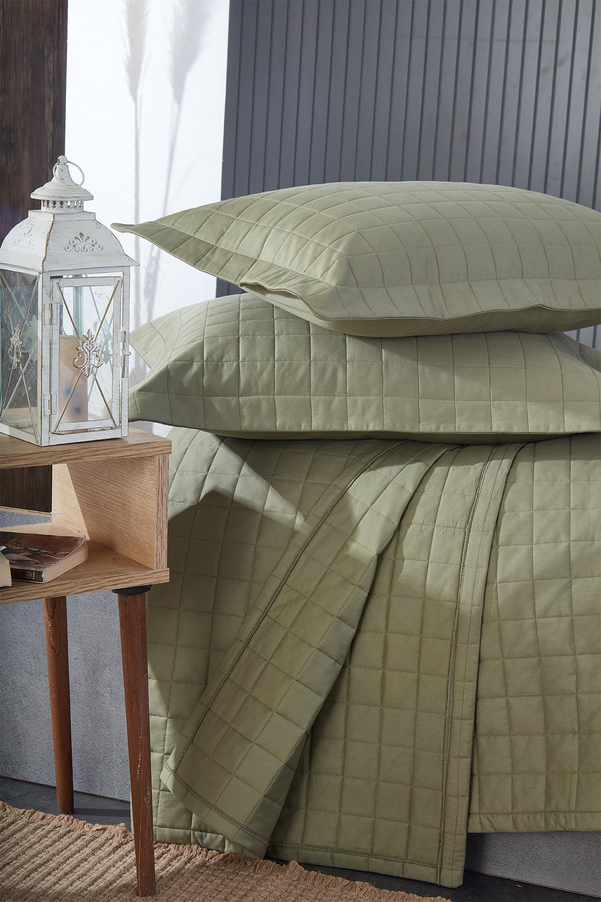 Green quilted double bedspread and pillows, modern bedroom decor