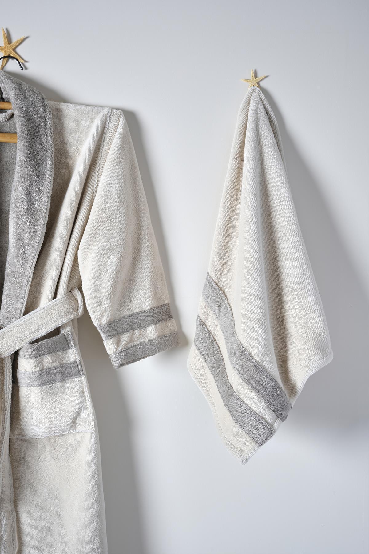Gray striped cotton men's bathrobe and towel set hanging on the wall