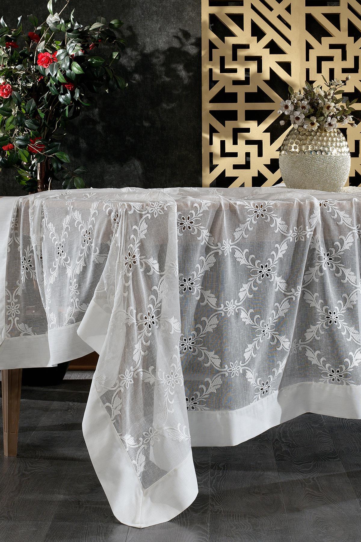 Stain-resistant white tablecloth with floral lace pattern, shown on a modern decorated table