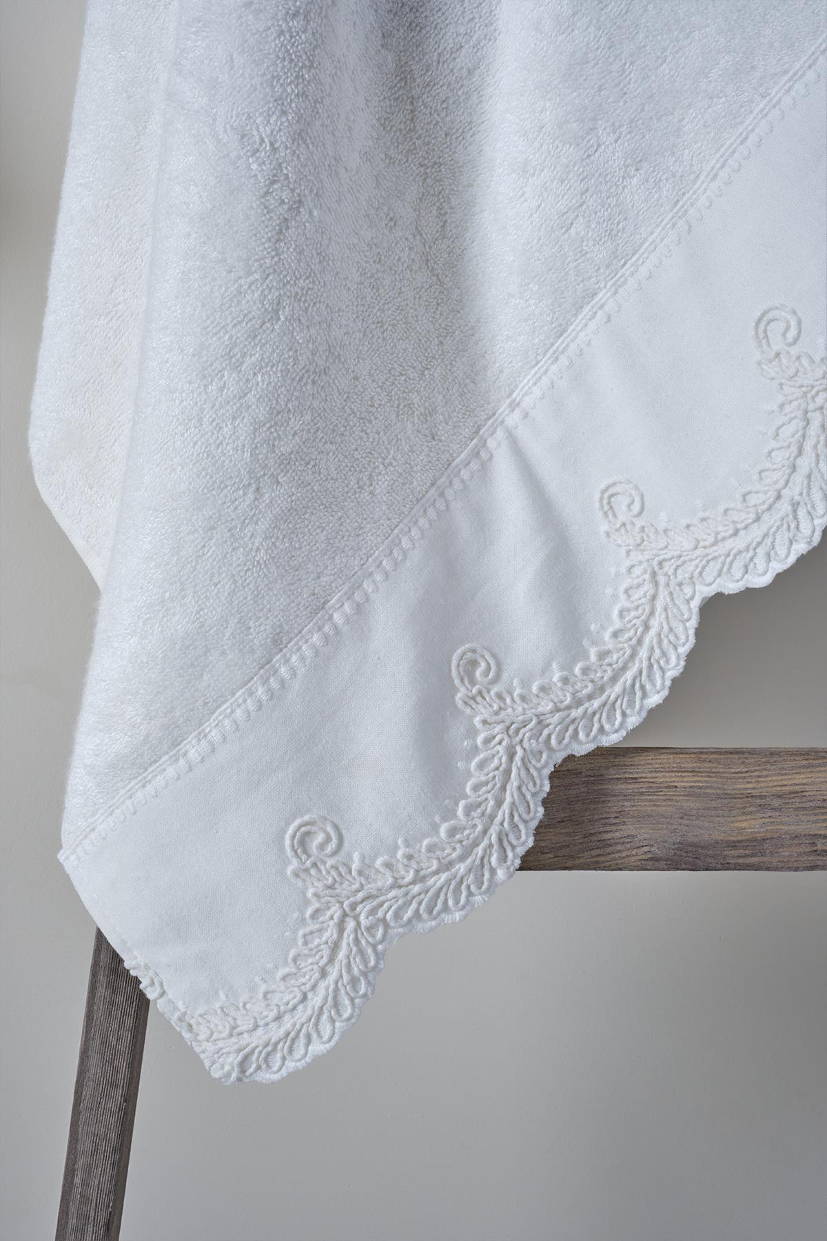 White cotton face towel with embroidered edges, 50x90 cm, on a wooden hanger