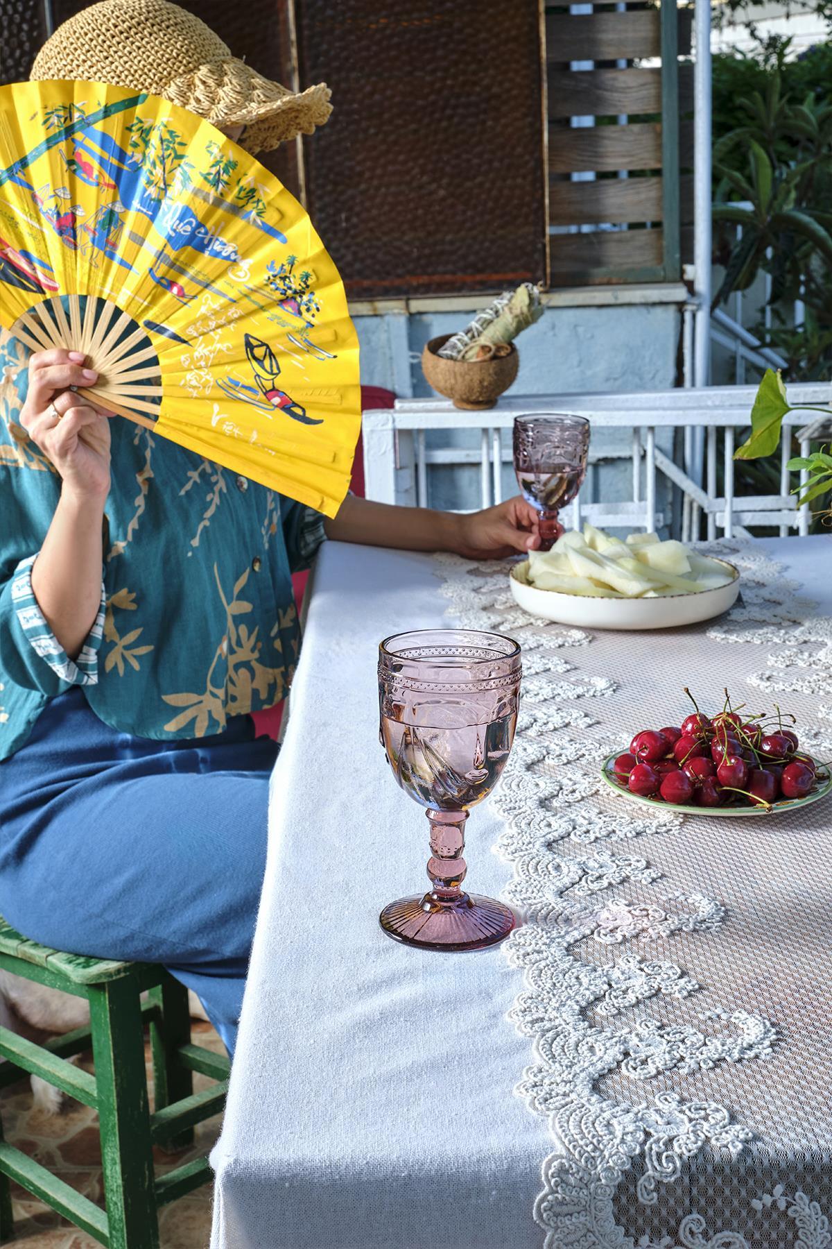 Lace-embroidered tablecloth, outdoor dining table set with cherries and elegant glasses