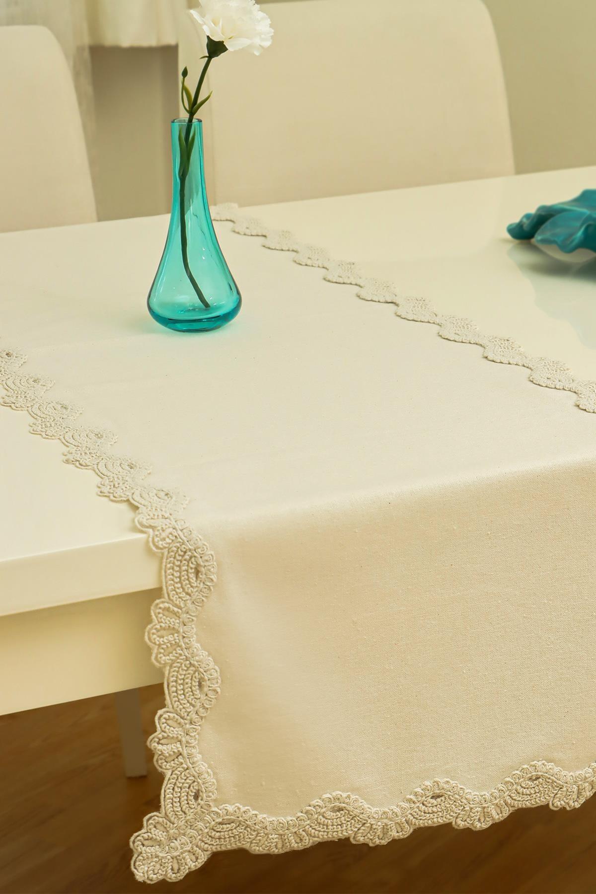 Cream lace-detailed table runner with a decorative vase on a modern dining table