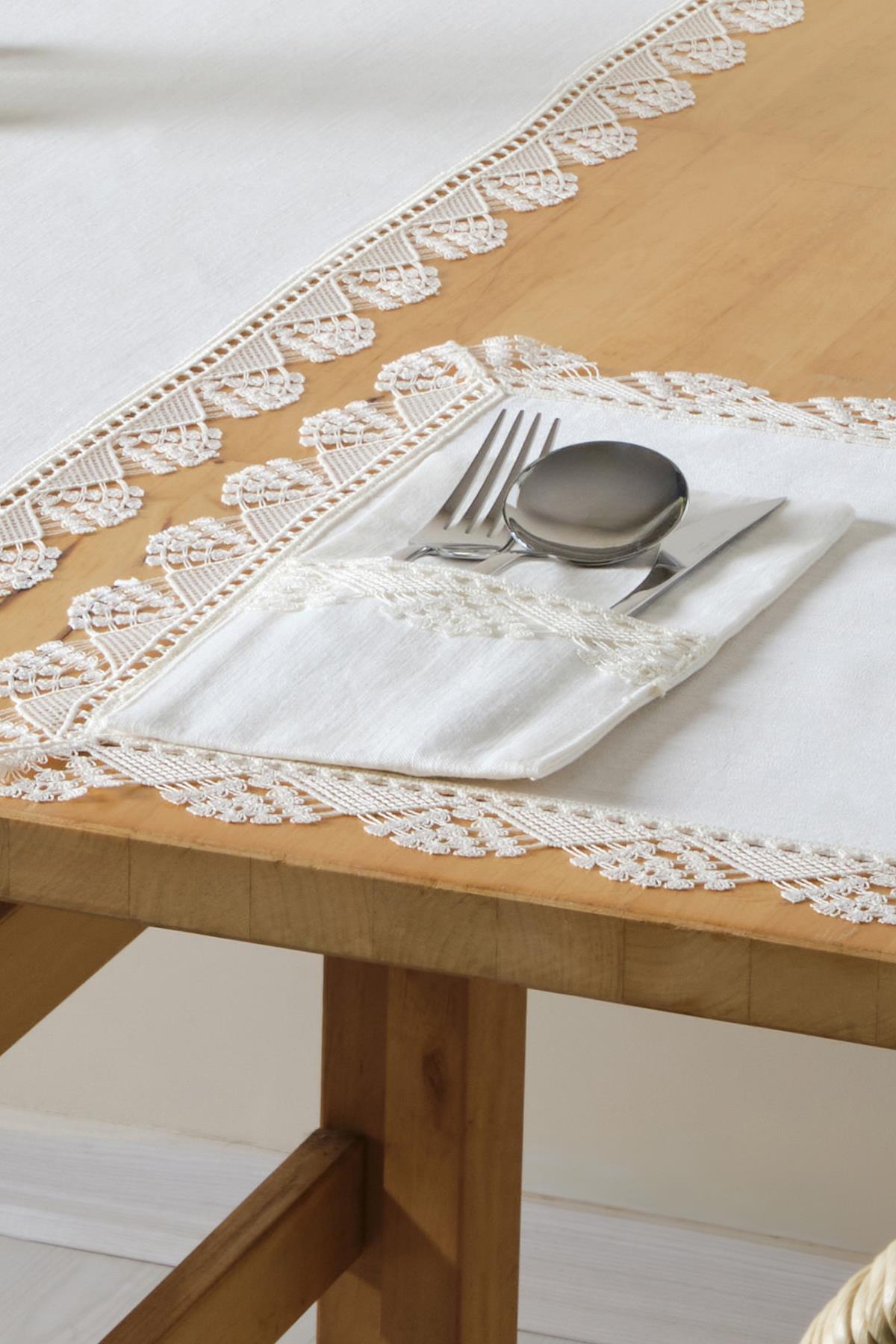 Lace tablecloth and white napkin set with cutlery, on a wooden table