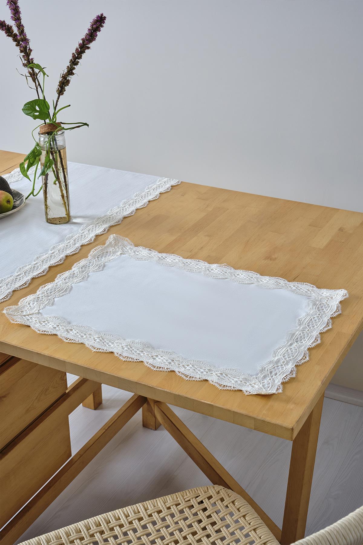 White lace-edged placemat set on a wooden table, decorative table setting