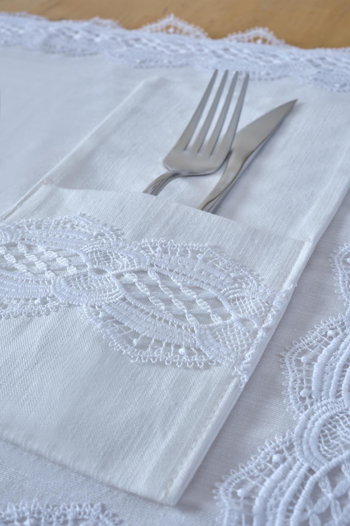 Fork and knife in a white fabric napkin holder with lace detail, table decoration