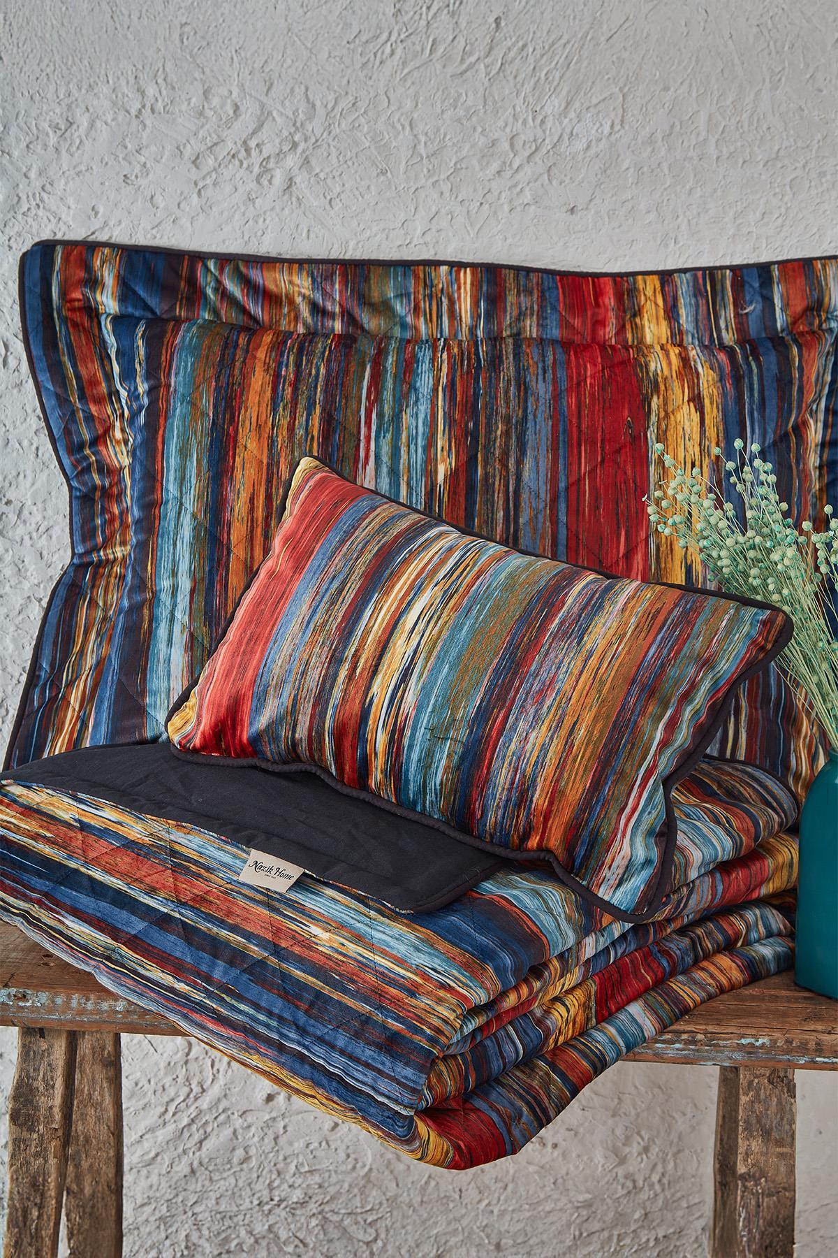 Double bedspread and pillow with a colorful striped pattern, on a rustic background.