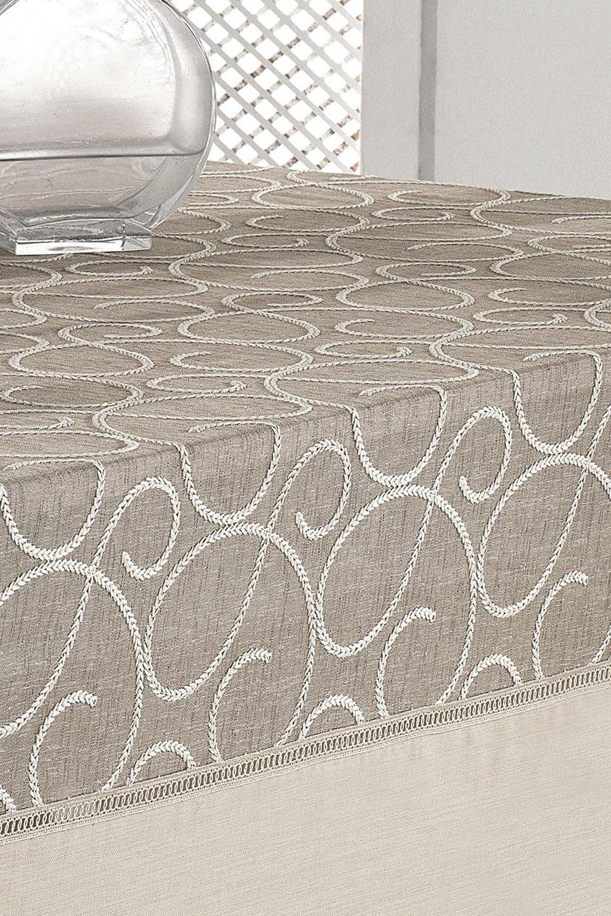Beige patterned stain-resistant, easy-care tablecloth, simple vase on a rectangular table