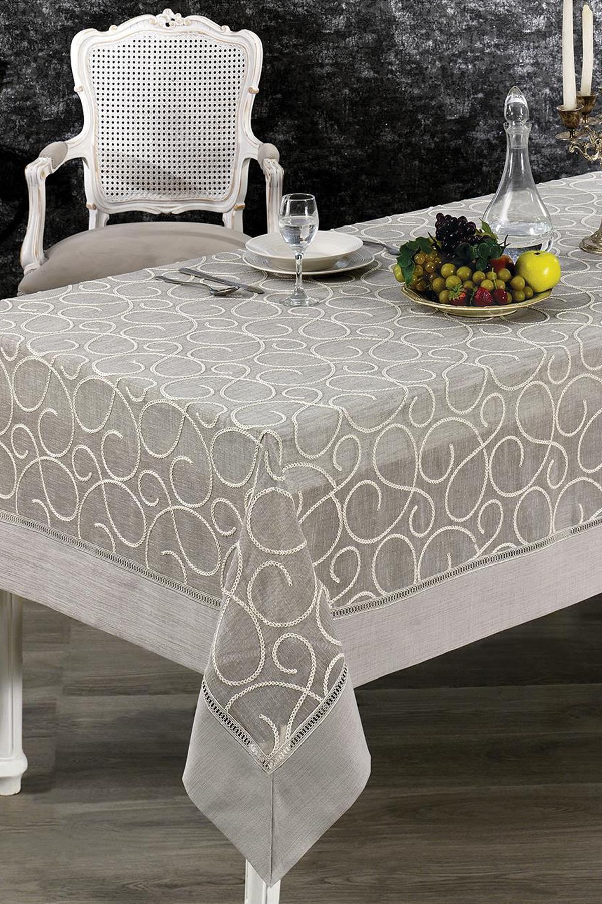 Patterned, stain-resistant tablecloth, set on an elegant table with a fruit bowl and a glass pitcher.
