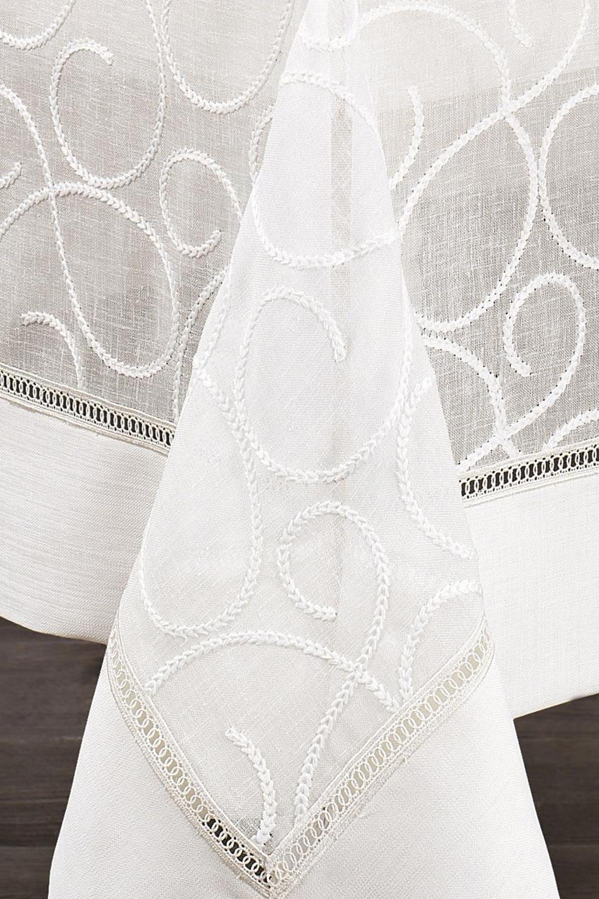 White patterned stain-resistant tablecloth, easy-care fabric, with decorative edge detailing.