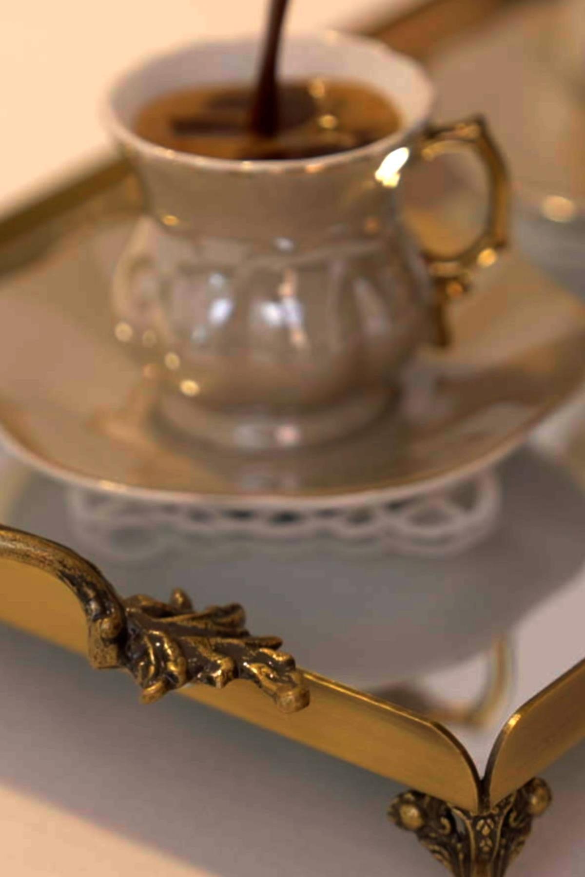 Coffee cup on a small, distressed tray with elegant handles, stylish presentation detail