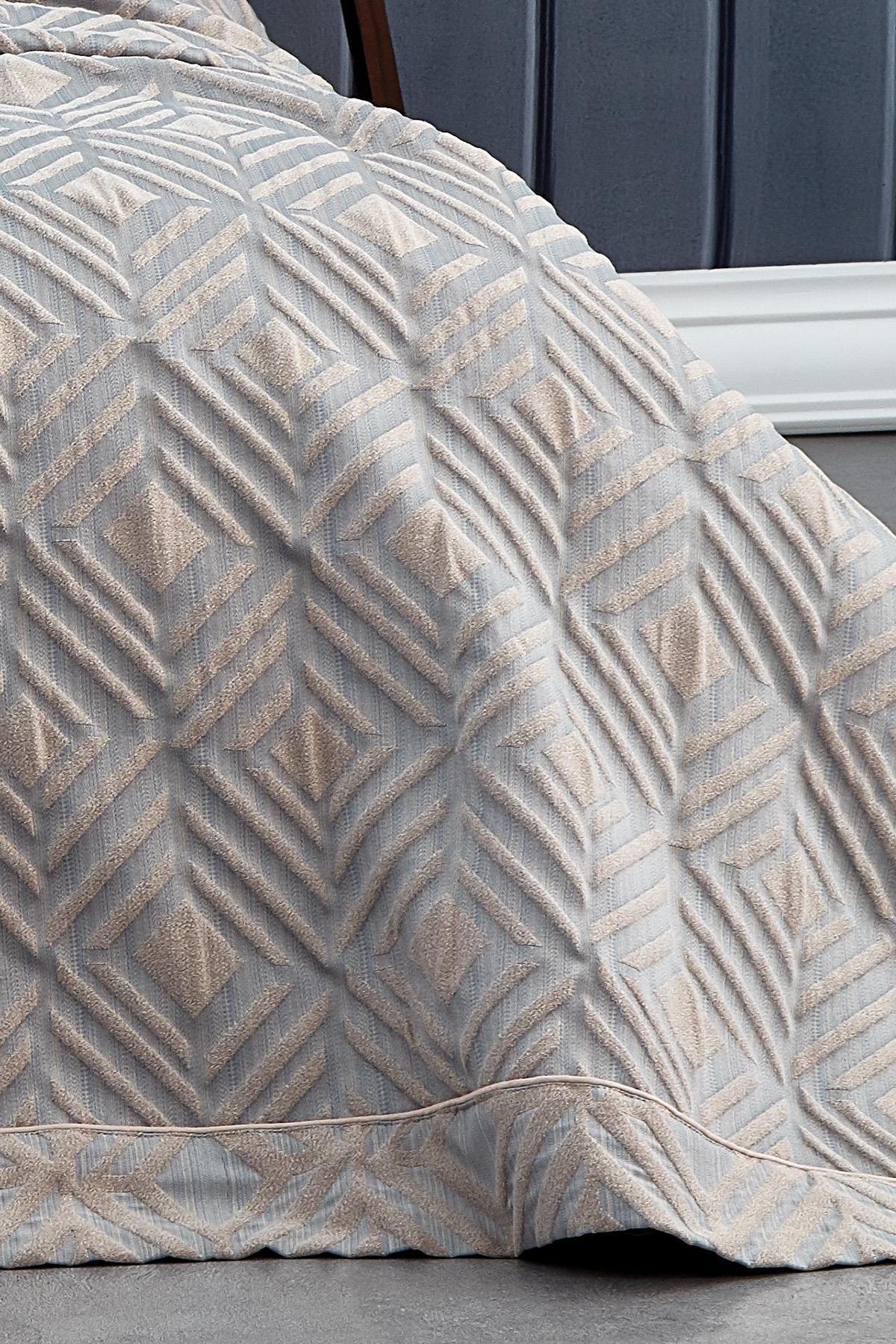 Detail view of a gray and beige geometric patterned jacquard double bedspread