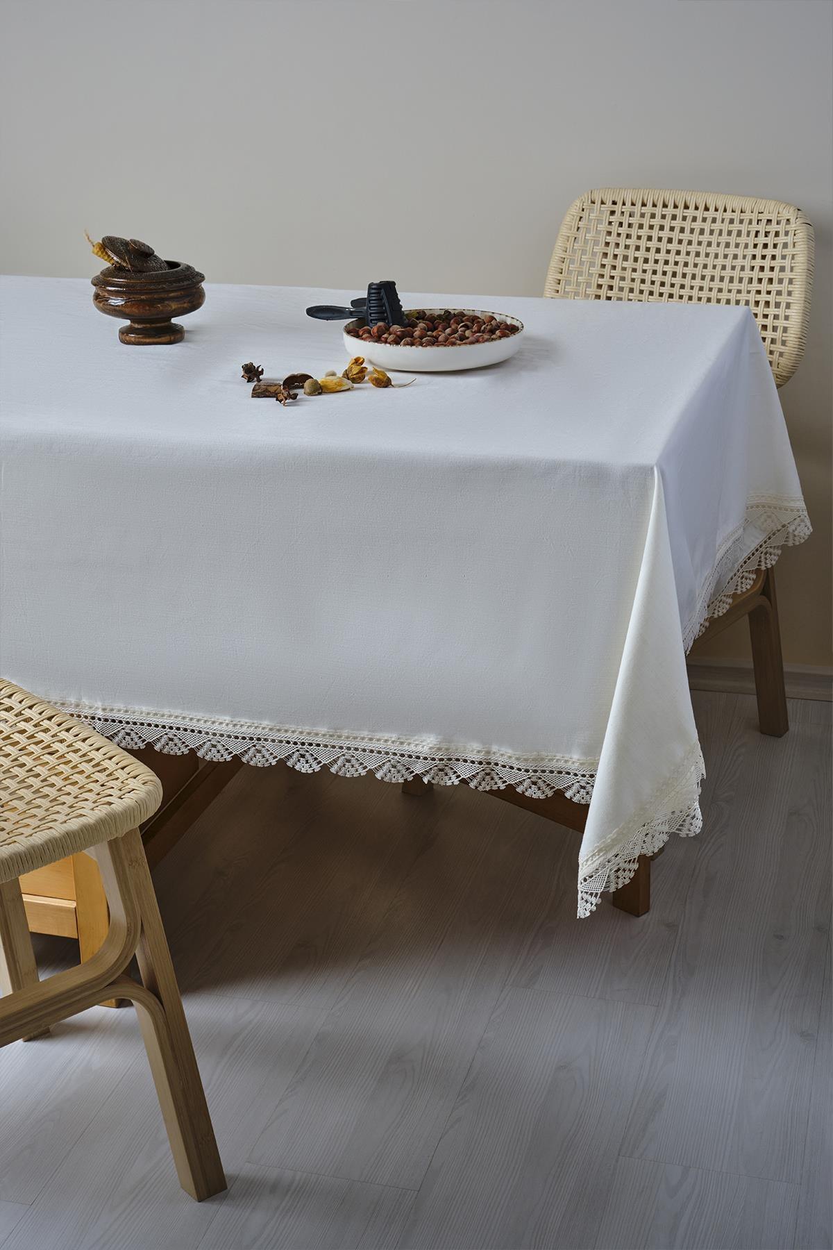 Lace-detailed, stain-resistant white tablecloth on a modern wooden table and chair
